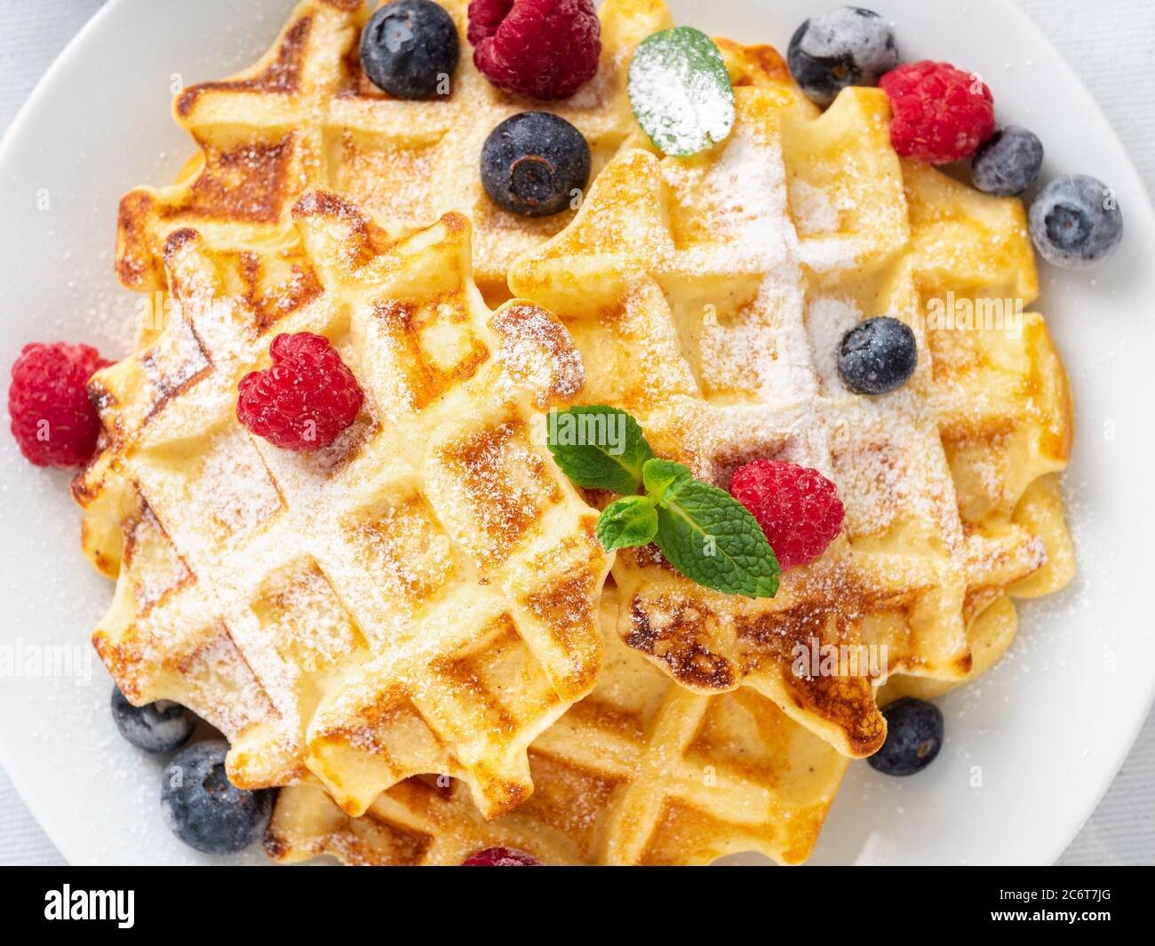 Gaufres belges avec framboises, bleuets, caillé et thé, vue du dessus. Banque D'Images