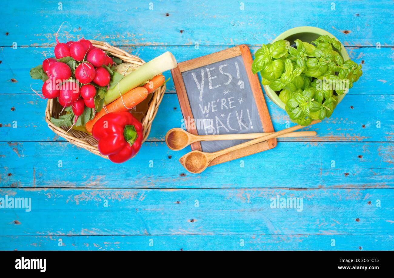 Restaurant annonçant la réouverture sur le tableau noir après le verrouillage de la couronne, la gastronomie, l'arrêt de l'entreprise alimentaire.aliments ingrédients et message oui nous sommes ba Banque D'Images