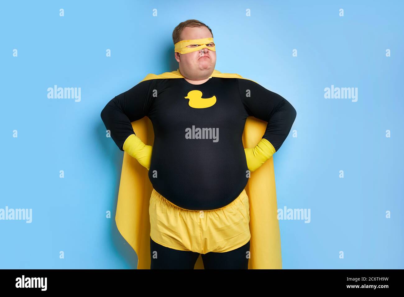portrait du super-héros de nettoyage enthousiaste isolé sur fond bleu. canard jaune est un symbole de bain et de nettoyage. l'homme est prêt à nettoyer Banque D'Images