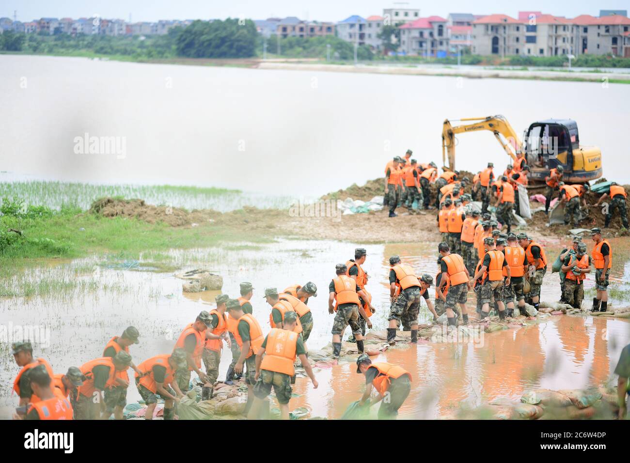 Poyang, Chine. 12 juillet 2020. Des policiers armés déplacent des sacs de sable pour le renforcement des digues dans le comté de Poyang, province de Jiangxi, en Chine orientale, le 12 juillet 2020. Selon le département provincial des ressources en eau, le lac Poyang, le plus grand lac d'eau douce de Chine situé dans la province orientale de Jiangxi, a connu dimanche une hausse record de son niveau d'eau. Vers 12 h 00 dimanche, le niveau d'eau de la station hydrologique de Xingzi du lac a augmenté à 22.53 mètres, 0.01 mètres plus haut que le record de 1998, et a continué à monter, a déclaré le ministère. (Photo de Cao Xianxun/Xinhua) crédit: Xinhua/A Banque D'Images