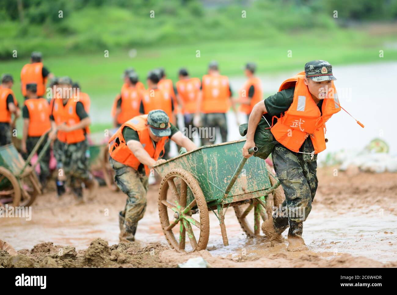 Poyang, Chine. 12 juillet 2020. Des policiers armés déplacent des sacs de sable pour le renforcement des digues dans le comté de Poyang, province de Jiangxi, en Chine orientale, le 12 juillet 2020. Selon le département provincial des ressources en eau, le lac Poyang, le plus grand lac d'eau douce de Chine situé dans la province orientale de Jiangxi, a connu dimanche une hausse record de son niveau d'eau. Vers 12 h 00 dimanche, le niveau d'eau de la station hydrologique de Xingzi du lac a augmenté à 22.53 mètres, 0.01 mètres plus haut que le record de 1998, et a continué à monter, a déclaré le ministère. (Photo de Cao Xianxun/Xinhua) crédit: Xinhua/A Banque D'Images