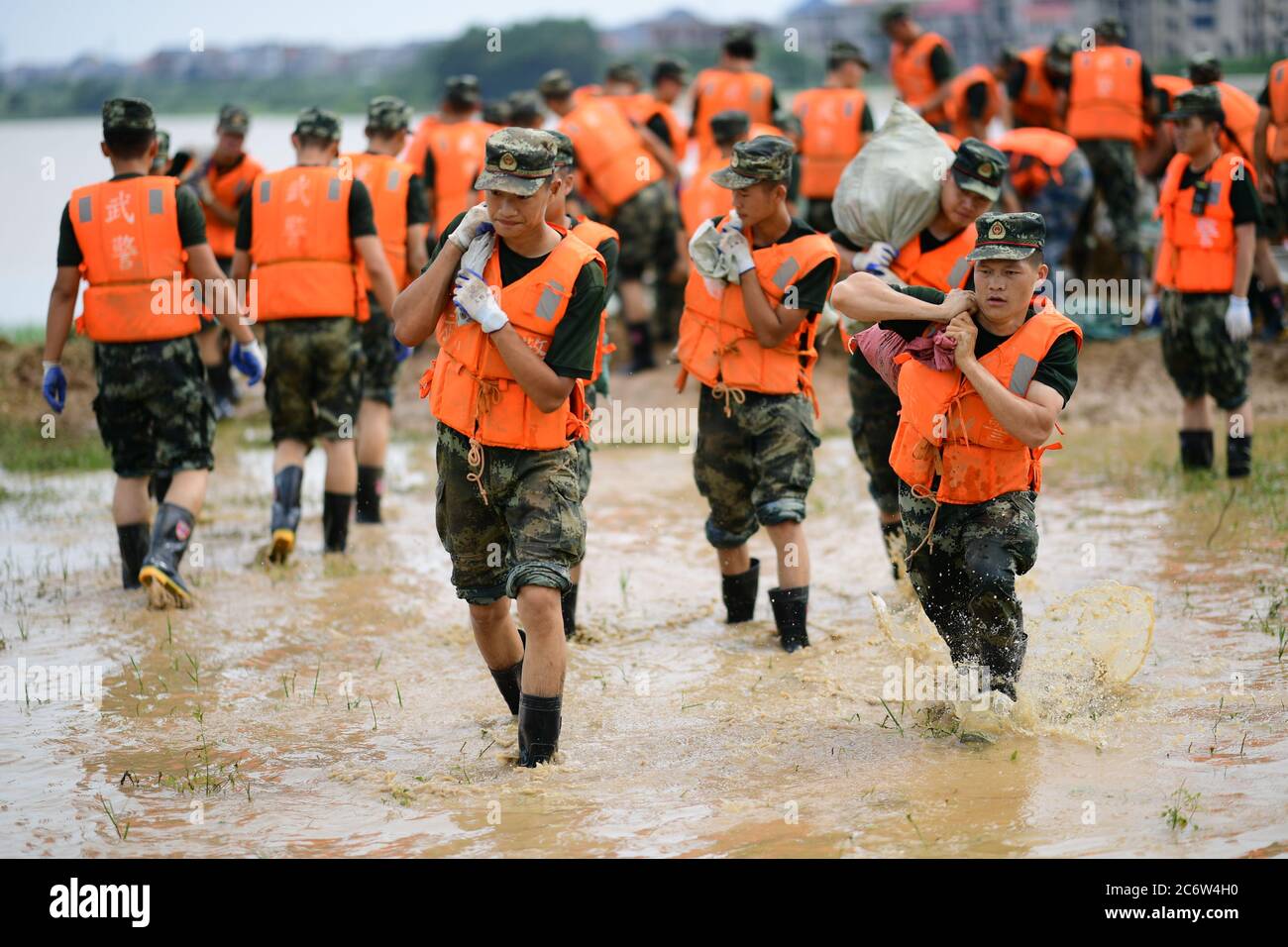 Poyang, Chine. 12 juillet 2020. Des policiers armés déplacent des sacs de sable pour le renforcement des digues dans le comté de Poyang, province de Jiangxi, en Chine orientale, le 12 juillet 2020. Selon le département provincial des ressources en eau, le lac Poyang, le plus grand lac d'eau douce de Chine situé dans la province orientale de Jiangxi, a connu dimanche une hausse record de son niveau d'eau. Vers 12 h 00 dimanche, le niveau d'eau de la station hydrologique de Xingzi du lac a augmenté à 22.53 mètres, 0.01 mètres plus haut que le record de 1998, et a continué à monter, a déclaré le ministère. (Photo de Cao Xianxun/Xinhua) crédit: Xinhua/A Banque D'Images