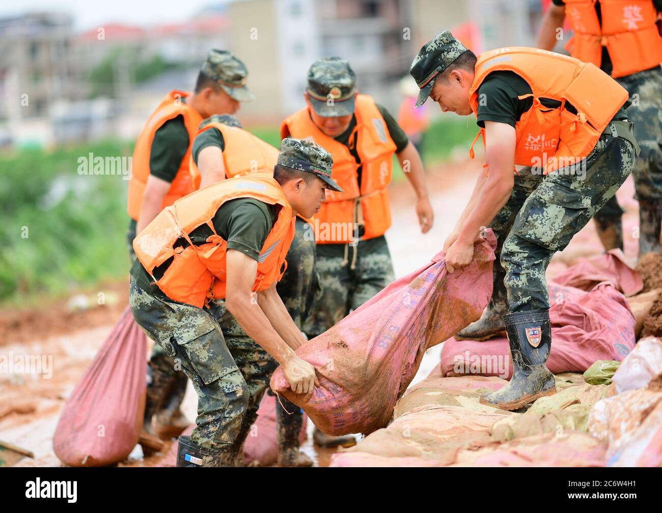 Poyang, Chine. 12 juillet 2020. Des policiers armés déplacent des sacs de sable pour le renforcement des digues dans le comté de Poyang, province de Jiangxi, en Chine orientale, le 12 juillet 2020. Selon le département provincial des ressources en eau, le lac Poyang, le plus grand lac d'eau douce de Chine situé dans la province orientale de Jiangxi, a connu dimanche une hausse record de son niveau d'eau. Vers 12 h 00 dimanche, le niveau d'eau de la station hydrologique de Xingzi du lac a augmenté à 22.53 mètres, 0.01 mètres plus haut que le record de 1998, et a continué à monter, a déclaré le ministère. (Photo de Cao Xianxun/Xinhua) crédit: Xinhua/A Banque D'Images
