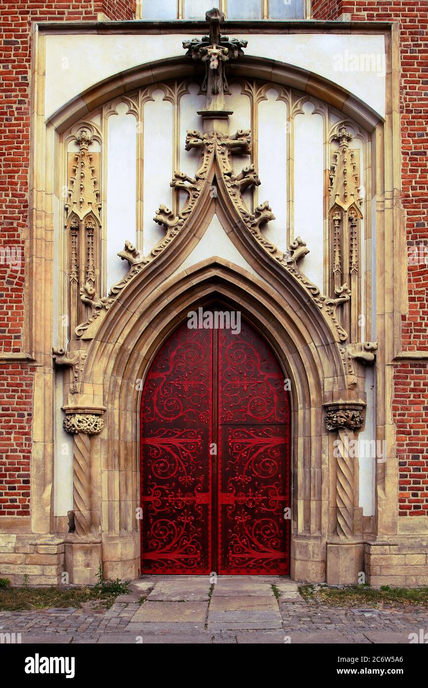 Double porte d'entrée en bois d'époque de l'ancien monastère médiéval abritant le musée d'architecture de Pologne orné de forge en fer peint en rouge. BER Banque D'Images