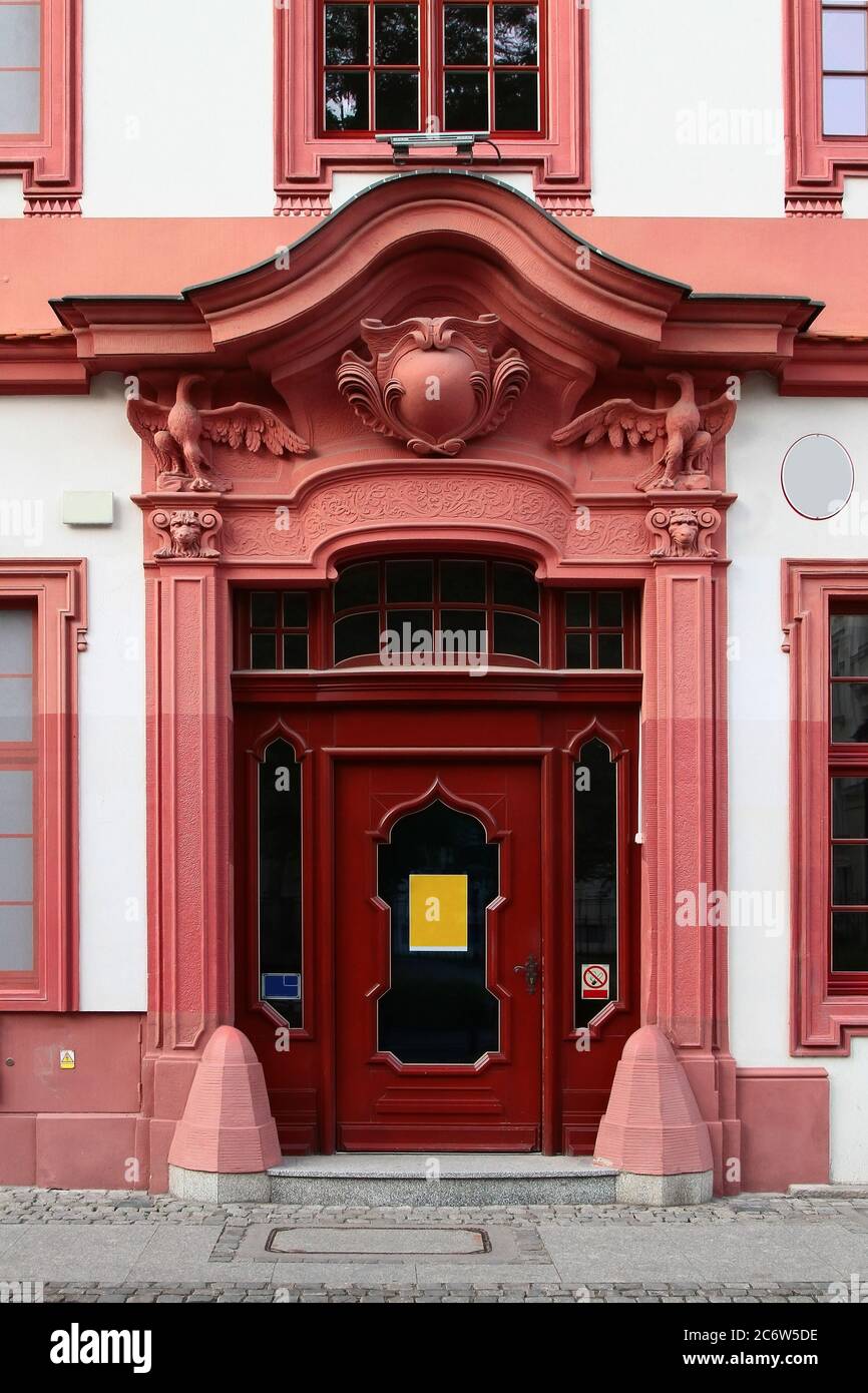 Belle porte d'entrée rouge décorée de pilastres et de blason. Wroclaw. Pologne. Banque D'Images