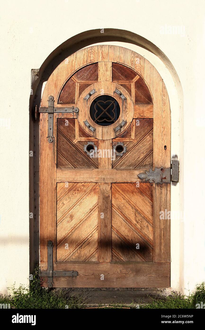 Porte d'entrée en bois d'époque voûtée avec fenêtre ronde décorée  d'éléments en fer rouillé. Prague. République tchèque Photo Stock - Alamy
