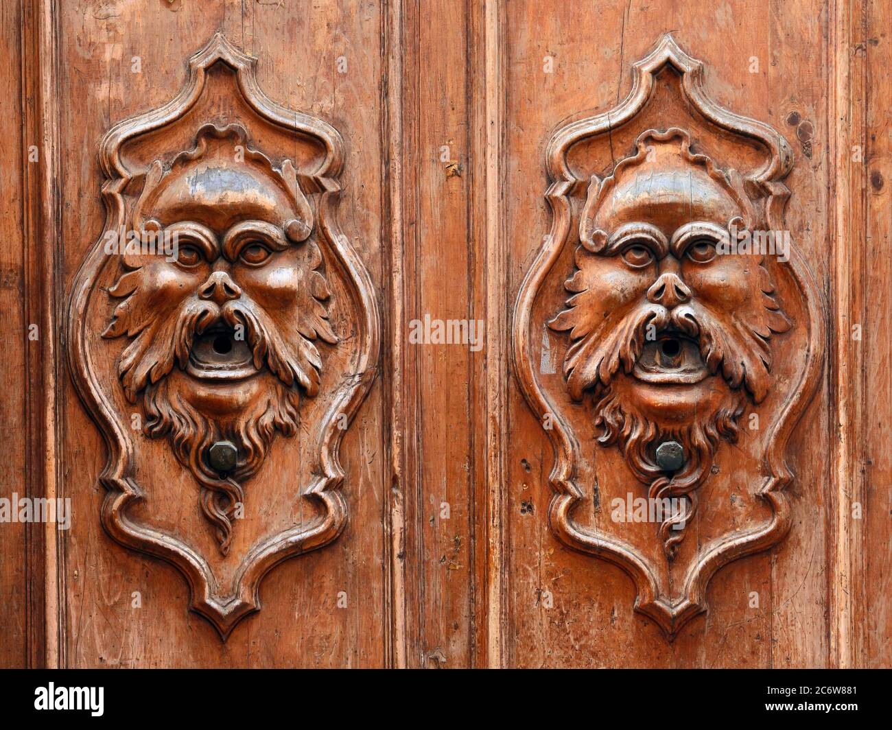 Éléments décoratifs. Ensemble de deux portes d'entrée vintage avec sculptures en bois sous forme de visage d'homme avec moustache et barbe. Pise. Italie. Banque D'Images