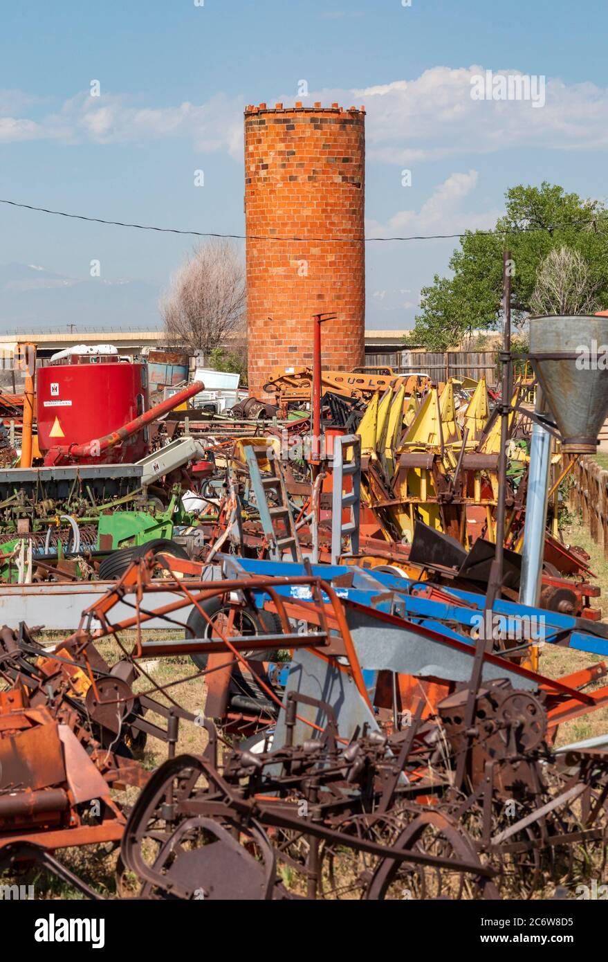LaSalle, Colorado - un vieux silo en briques se trouve au milieu d'un chantier de construction d'équipement agricole. Banque D'Images