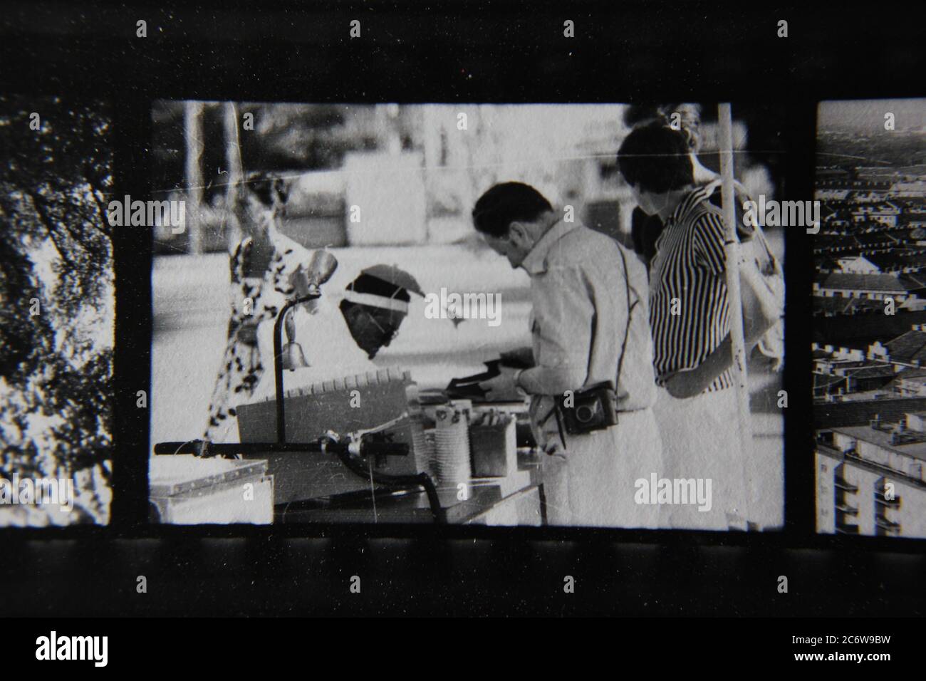 Fin 70s vintage contact imprimer noir et blanc photographie d'un homme fournissant un service à partir d'un kiosque de rue. Banque D'Images