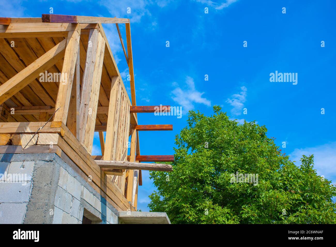 nouvelle maison en bois avec arbre et ciel bleu. photo industrielle de construction Banque D'Images