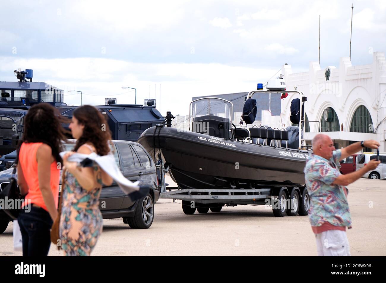 Véhicules de police antiémeute et 2 femmes les regardant à Lisbonne, Portugal et bateau de police sur une remorque Banque D'Images