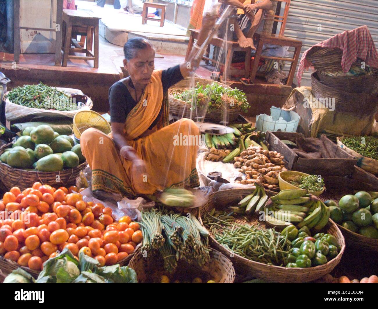 Une femme âgée vend des légumes dans un magasin situé sur un marché à Kolkata, en Inde, le 29 octobre 2007. Banque D'Images
