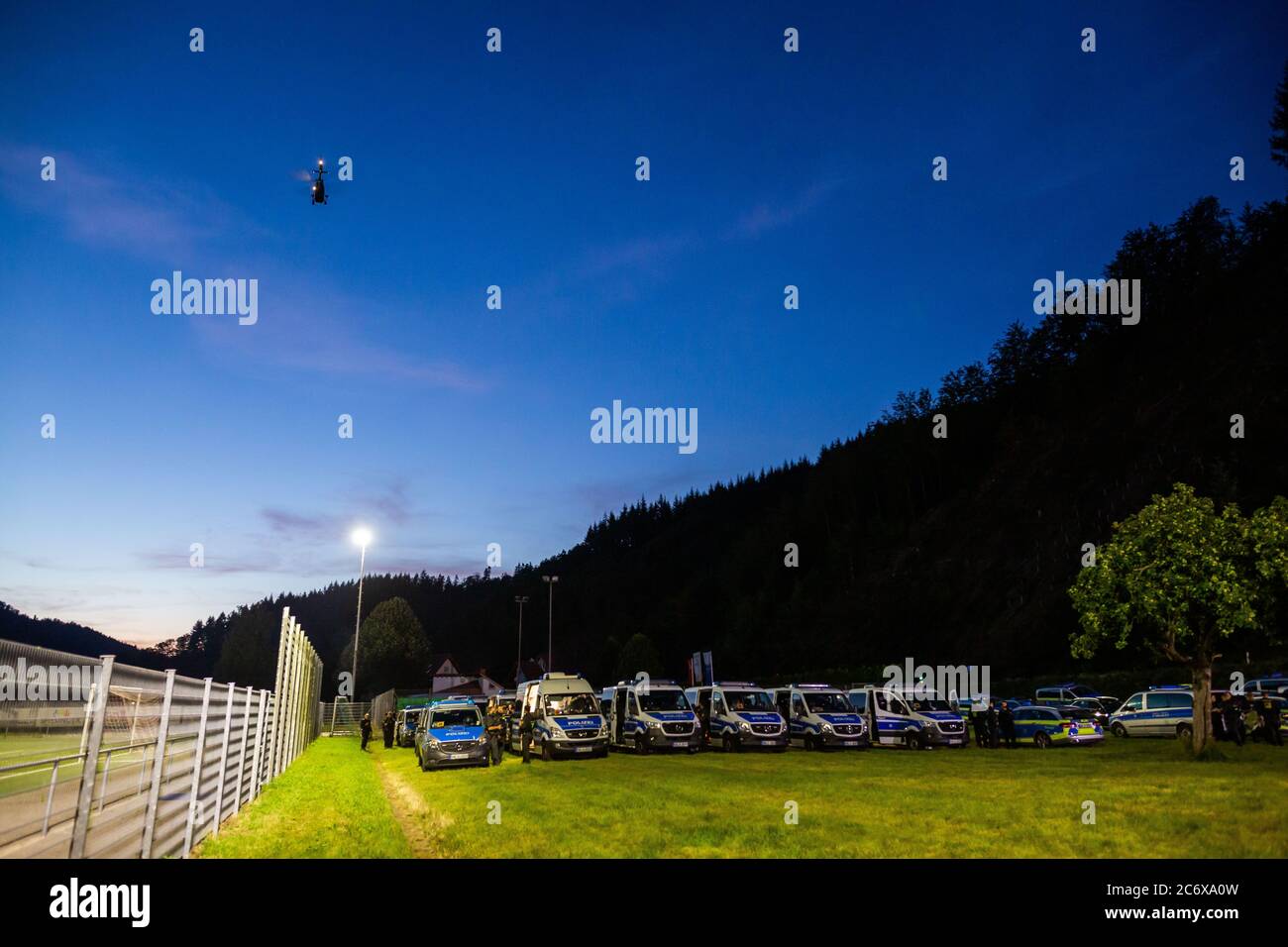Oppenau, Allemagne. 12 juillet 2020. Un hélicoptère de police survole au crépuscule près de la communauté d'Oppenau au au-dessus des forces de police anti-émeutes récemment arrivées, qui sont venues pour soulager leurs collègues sur place. Depuis ce matin, un grand contingent de police a cherché un homme armé qui aurait désarmé les officiers de contrôle pendant un contrôle et s'est enfui. La police cherche maintenant l'homme dans les bois qui bordent le village. Credit: Philipp von Ditfurth/dpa/Alay Live News Banque D'Images