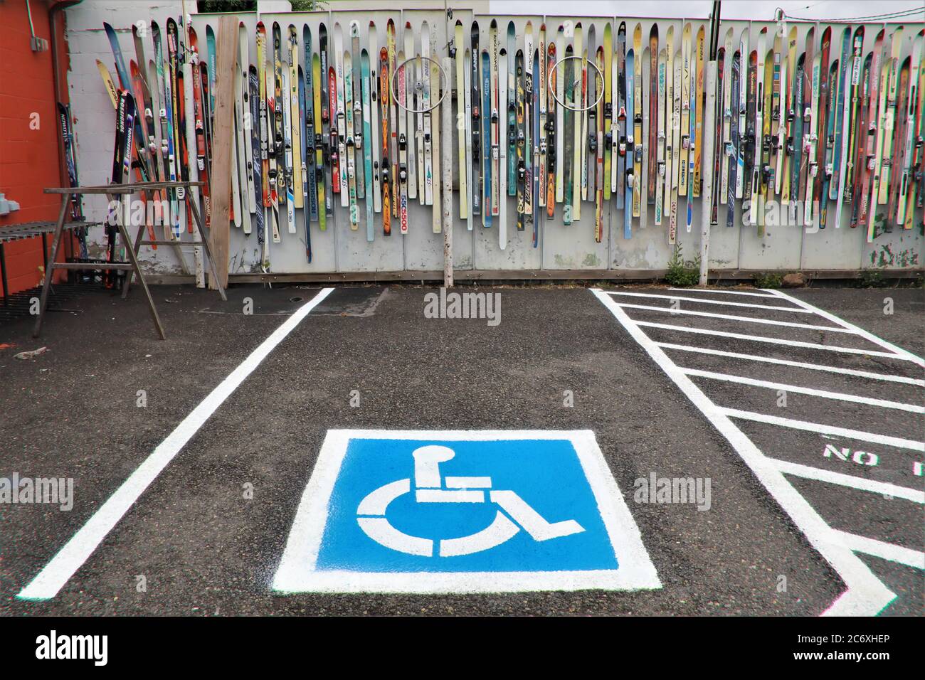 vieux skis utilisés comme décoration et art sur Un mur près du parking à Bend Oregon USA avec roues de vélo derrière la boutique de vélo et de ski Banque D'Images