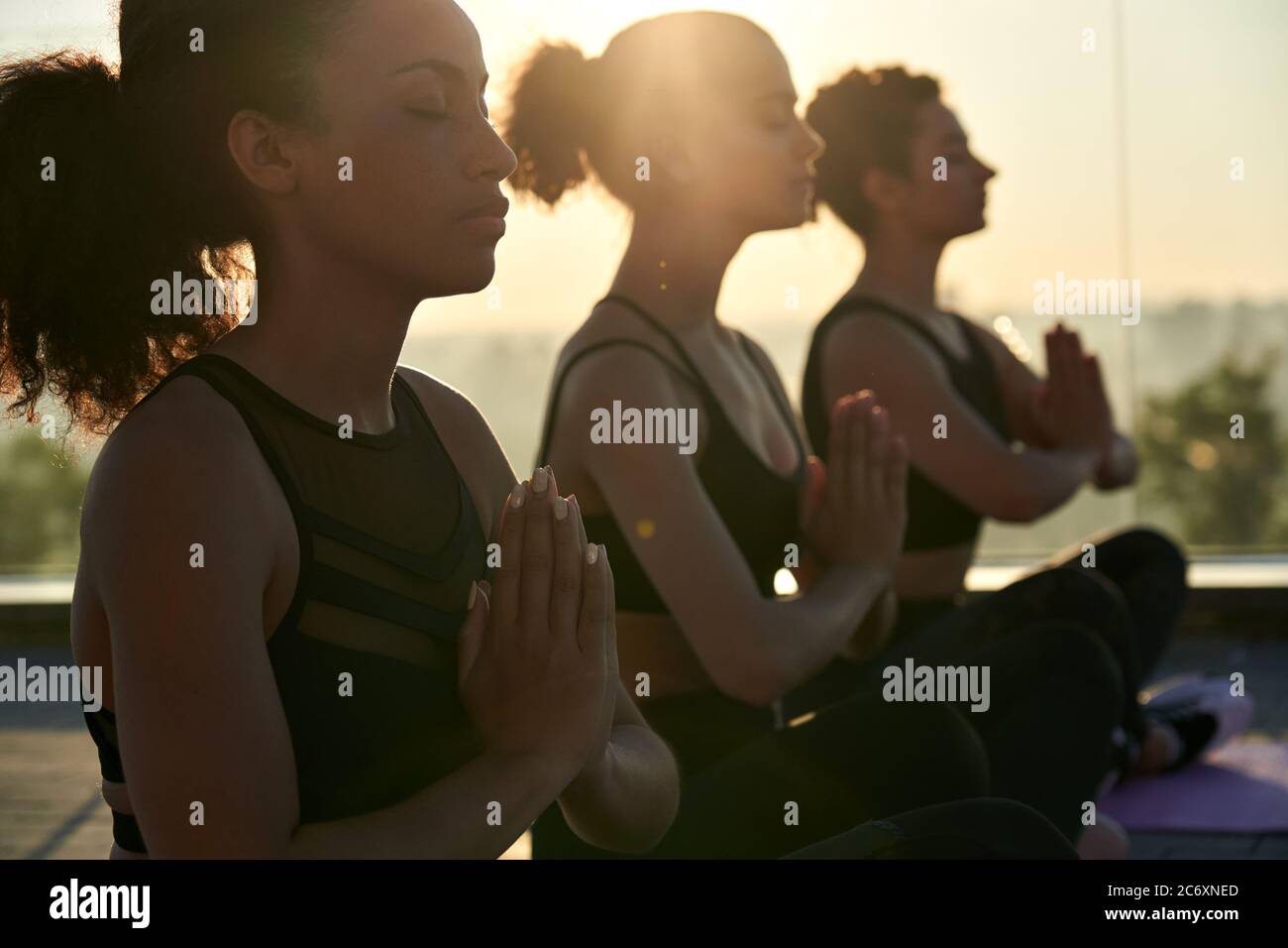 Calme serein African american femme méditant à l'extérieur de groupe de yoga cours. Banque D'Images