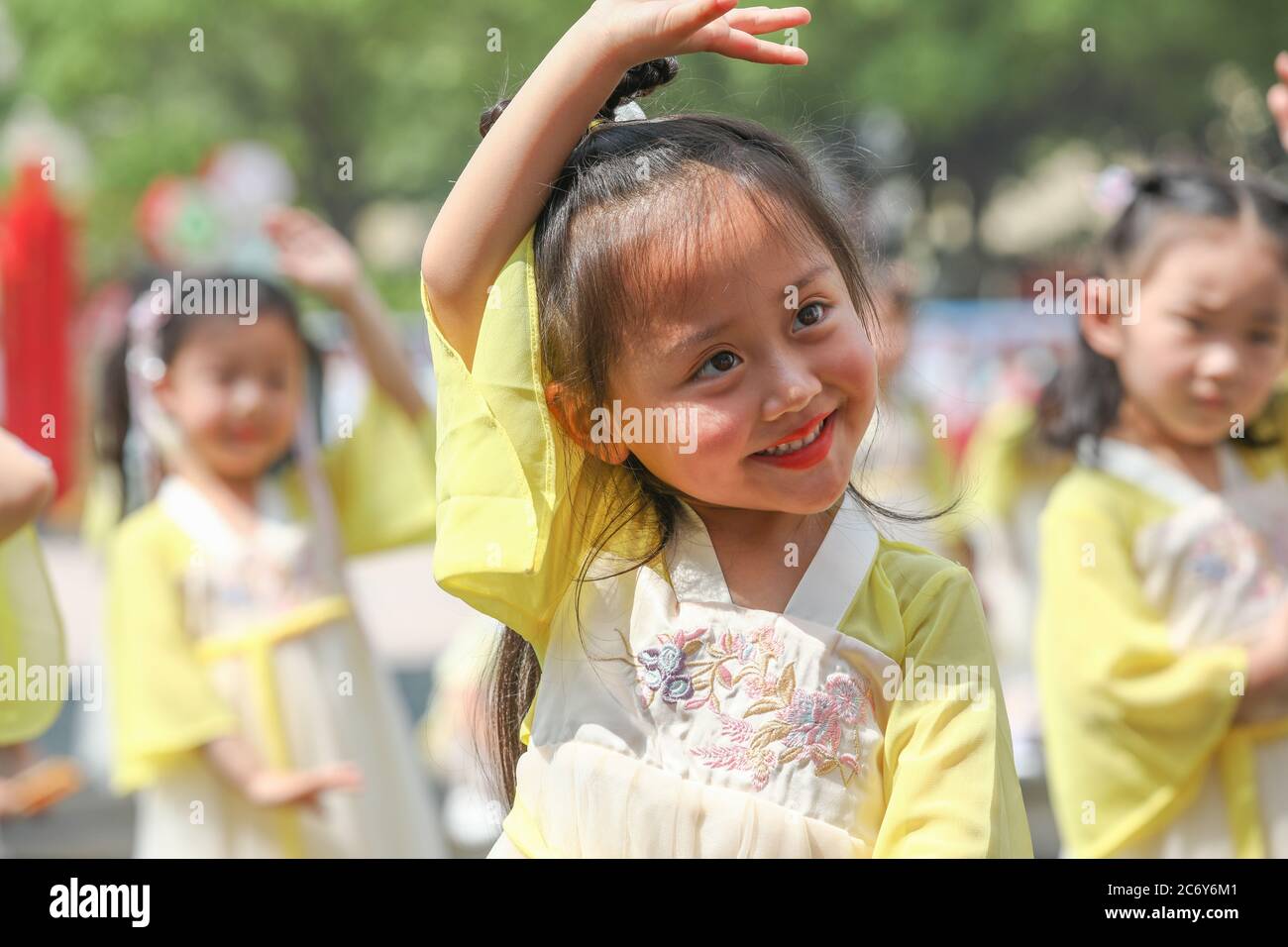 Vêtus de vêtements chinois anciens, les enfants dansent à la maternelle locale et font un sac de médecine parfumé traditionnel pour célébrer le prochain Dragon Banque D'Images