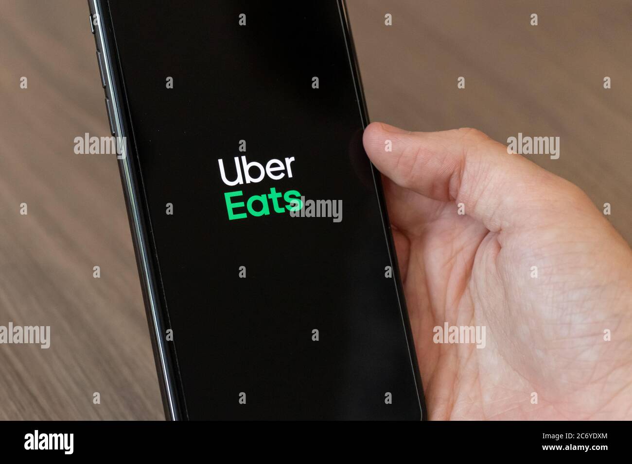 Personne utilisant un téléphone portable avec le logo Uber Eats, le service populaire de commande et de livraison de nourriture en ligne à l'écran. Banque D'Images