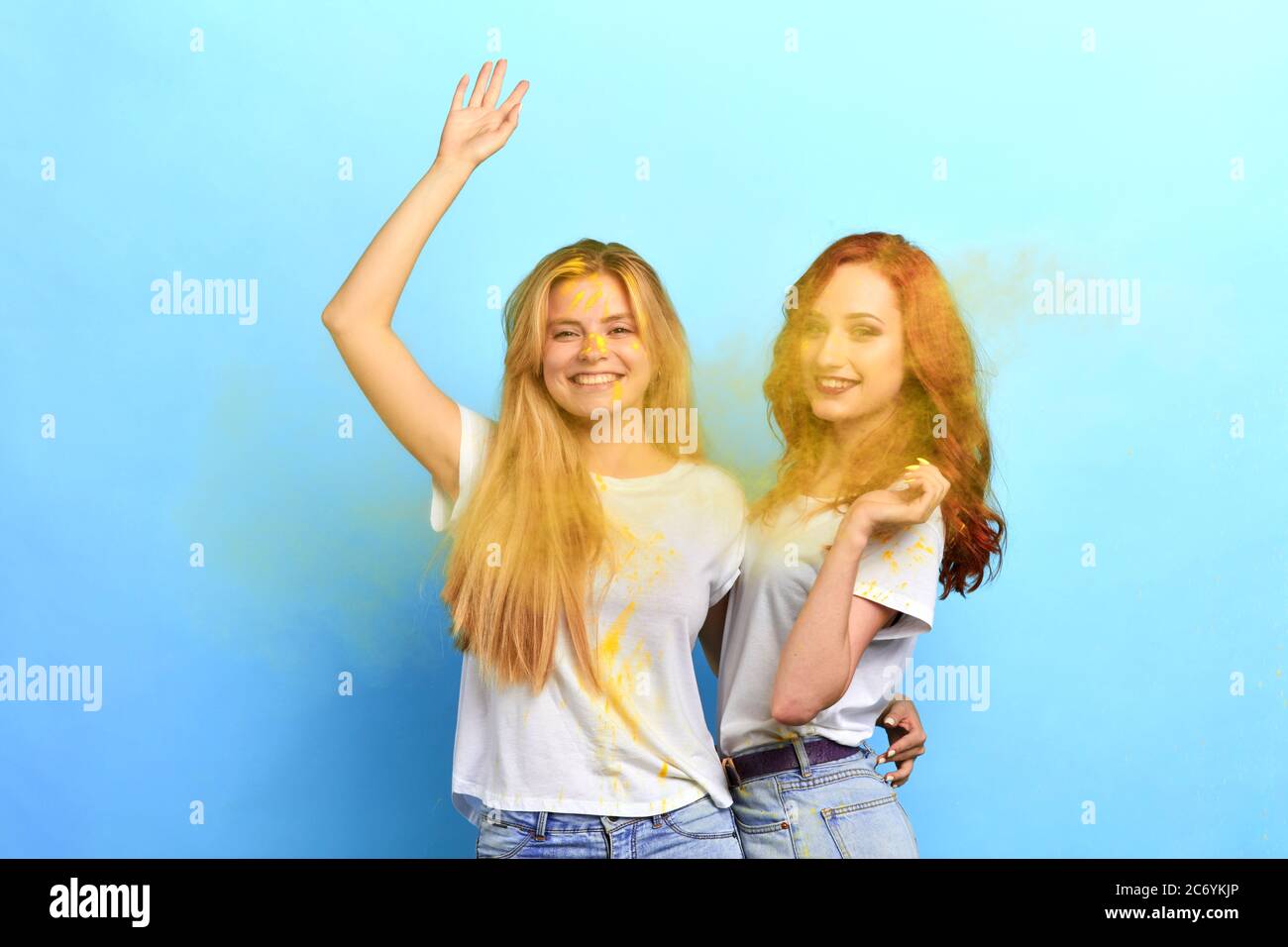 deux filles positives amusantes avec des visages sales peints regardant l'appareil photo. bonheur, sentiment et émotion. isolé fond bleu, stuido sh Banque D'Images