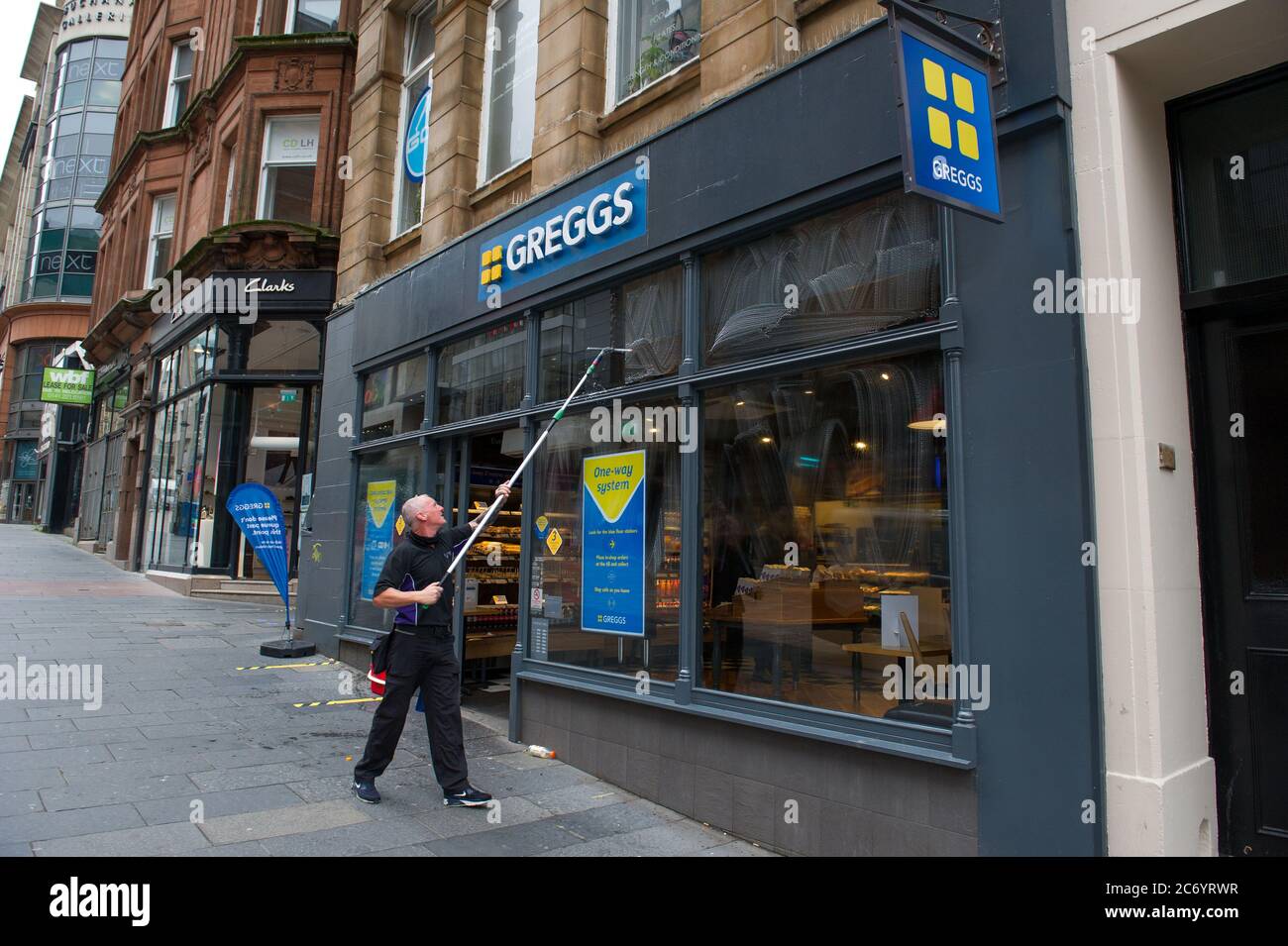 Glasgow, Écosse, Royaume-Uni. 13 juillet 2020. Photo: Un nettoyeur de fenêtre lave rapidement les fenêtres de magasin de Gregs pour qu'ils soient étincelants en début de matinée. Scènes de Buchanan Street dans le centre-ville de Glasgow. Crédit : Colin Fisher/Alay Live News Banque D'Images