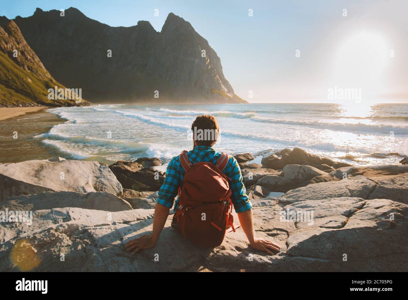 Homme assis sur la plage de Kvalvika profiter de la vue sur l'océan voyage vacances écotourisme plein air sac à dos en Norvège vie saine voyage d'été Banque D'Images