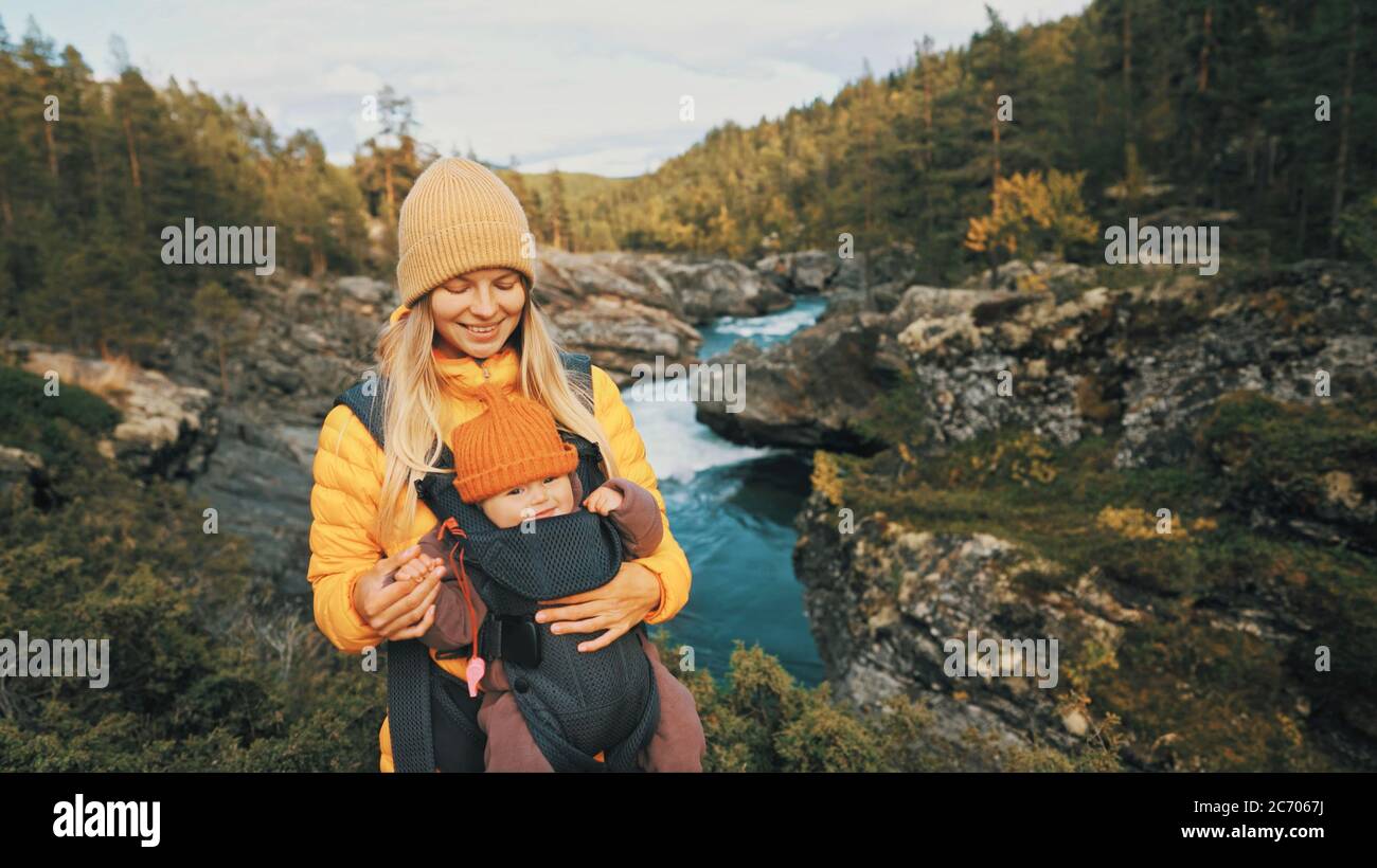 Mère marchant avec un porte-bébé dans la forêt famille voyageant en Norvège vacances en plein air femme avec enfant bébé ensemble sain style de vie automne mers Banque D'Images