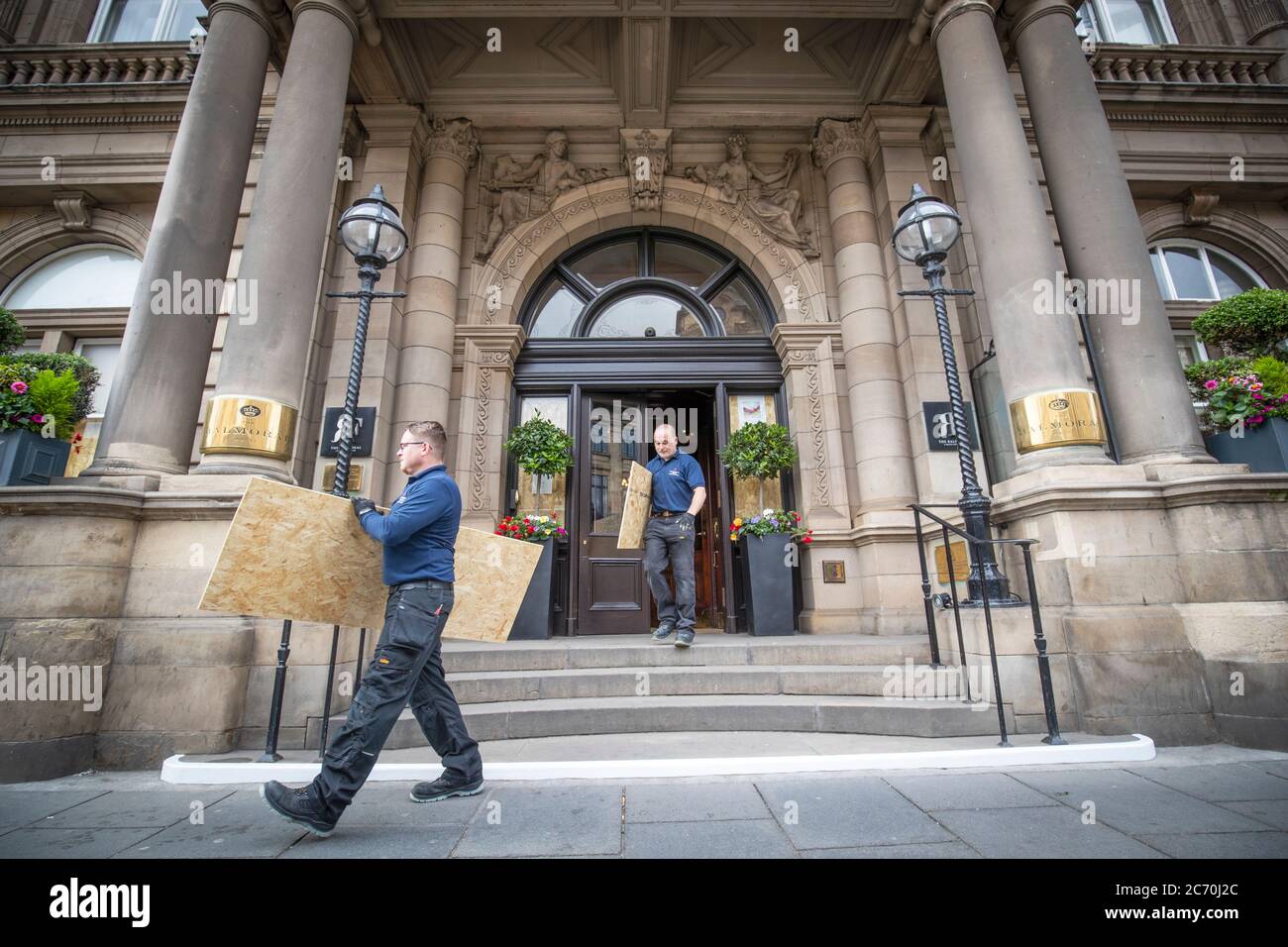 Les membres de l'équipe de maintenance du Balmoral, Édimbourg, retirent les panneaux de la porte d'entrée, les hôtels se préparant à la réouverture le mois prochain, alors que l'Écosse se prépare à lever d'autres restrictions de verrouillage du coronavirus. Banque D'Images