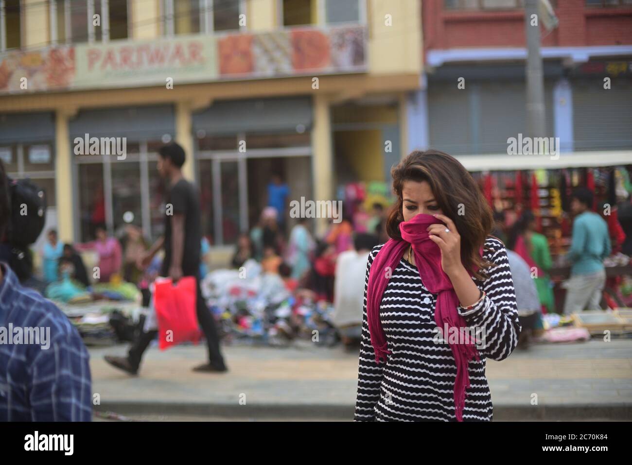 Une citoyenne qui couvre sa bouche et son nez alors qu'elle marche à travers une route à Katmandou, au Népal. Banque D'Images
