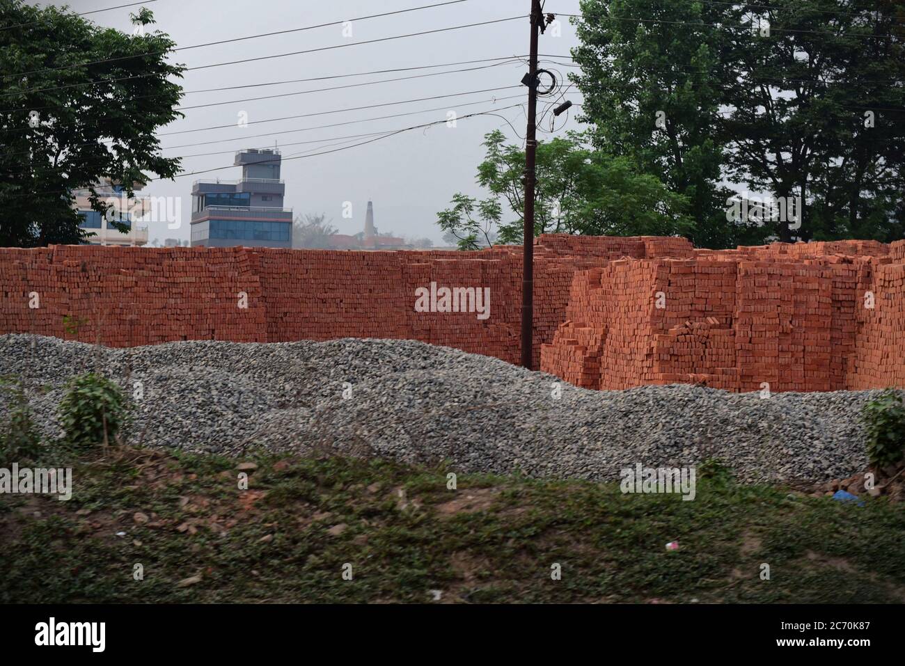 Une station de briques et de matériaux de construction pour les projets de reconstruction, à la périphérie de Katmandou, province de Bagmati Pradesh, Népal. L'essor de la croissance démographique, de l'urbanisation et des projets de construction exigent une grande quantité de matériaux de construction. L'extraction des matériaux, ainsi que la production de briques, ont contribué à la mauvaise qualité de l'air. Banque D'Images