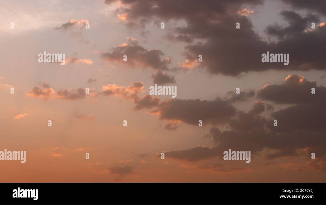 Ciel orangé avec nuages image d'arrière-plan Banque D'Images