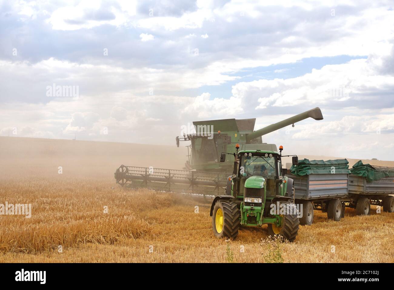 moissonneuse-batteuse et tracteur dans le champ de céréales pendant la récolte estivale Banque D'Images
