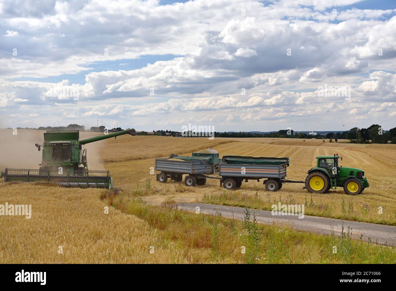 moissonneuse-batteuse et tracteur dans le champ de céréales pendant la récolte estivale Banque D'Images