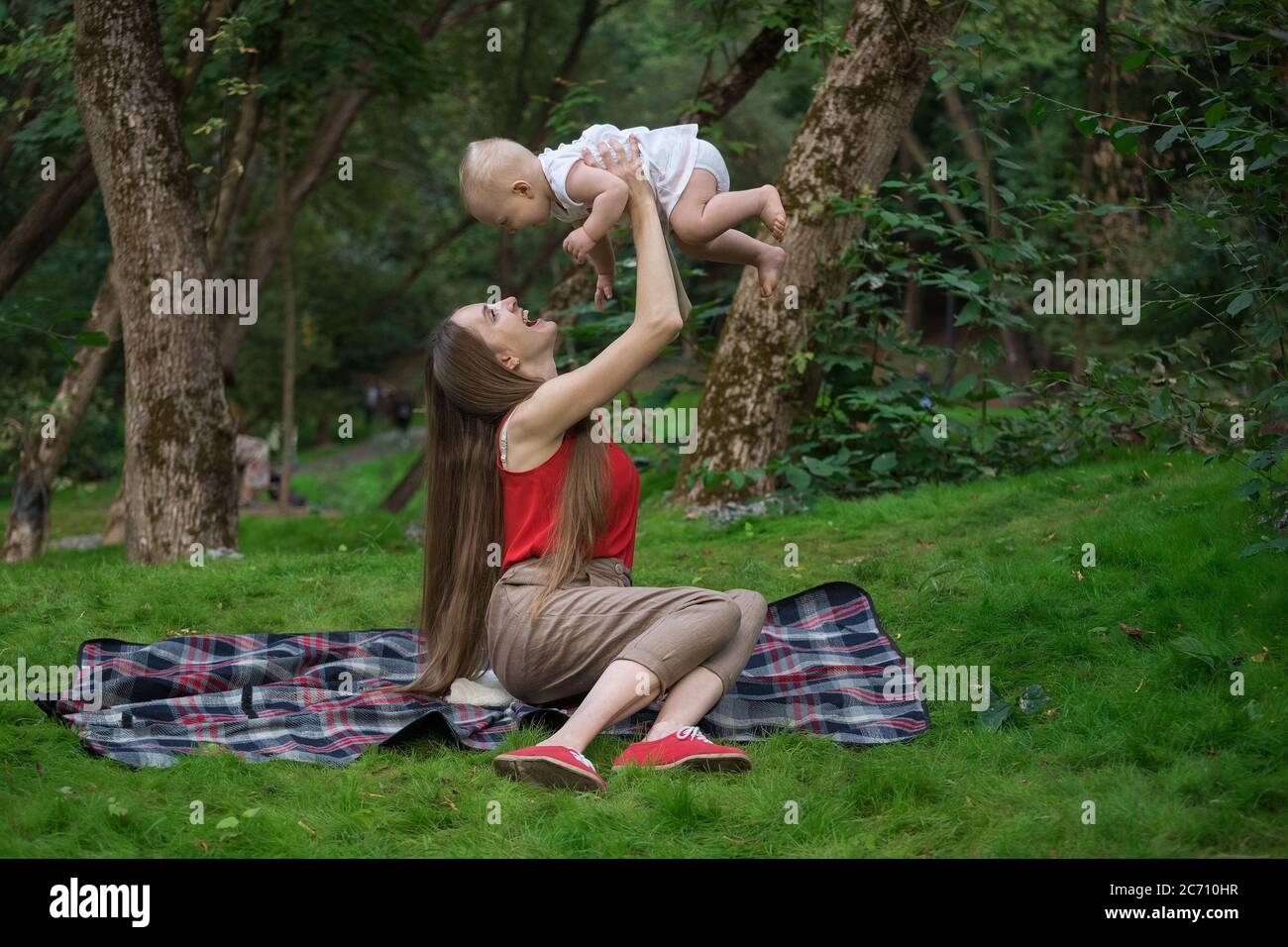 Mère joue avec bébé à l'extérieur. Plaisir aimant mère et bébé Banque D'Images