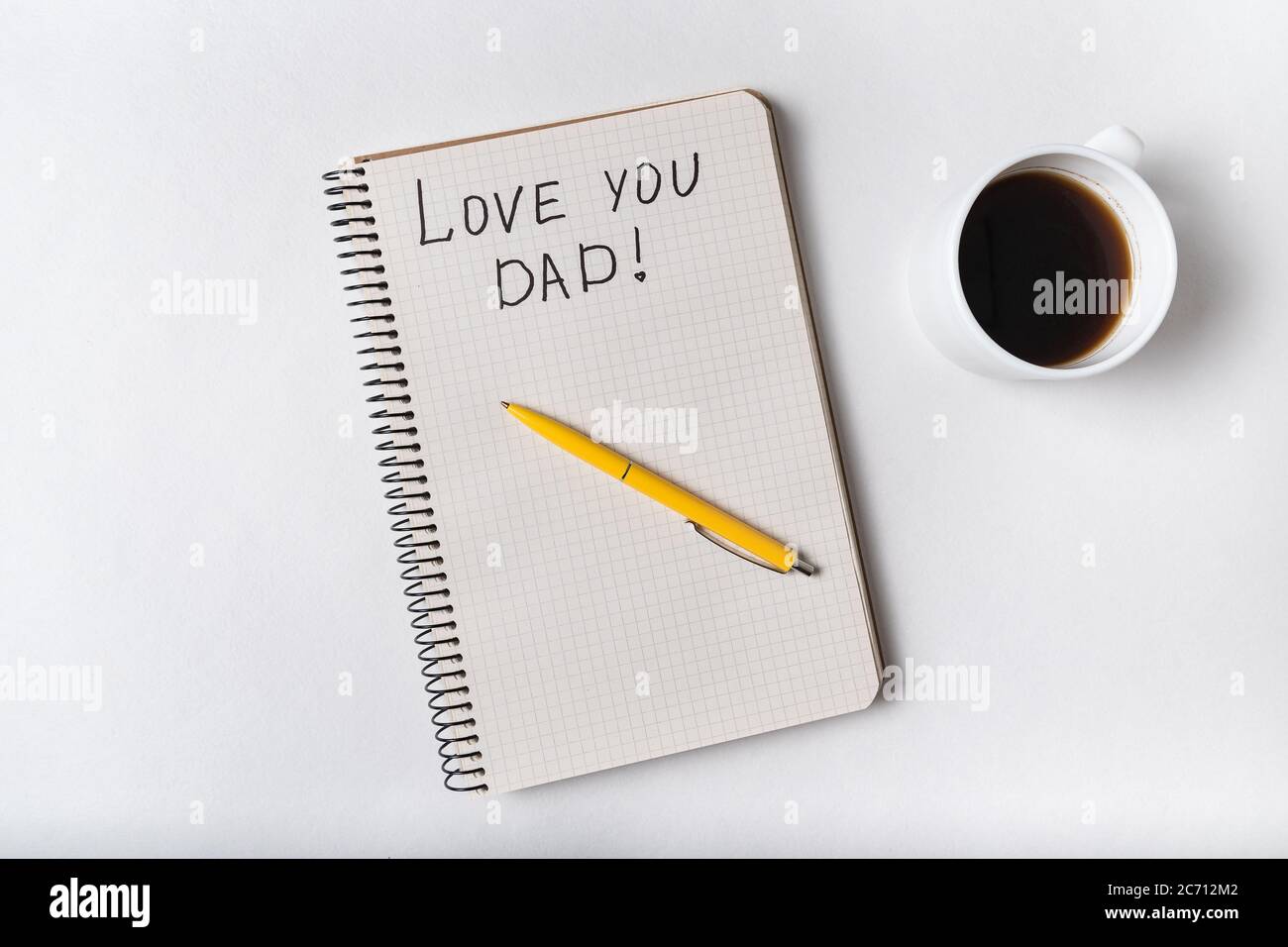 Jolie inscription dans le carnet Je T'AIME DAD. Café, bloc-notes et stylo. Vue de dessus. Banque D'Images