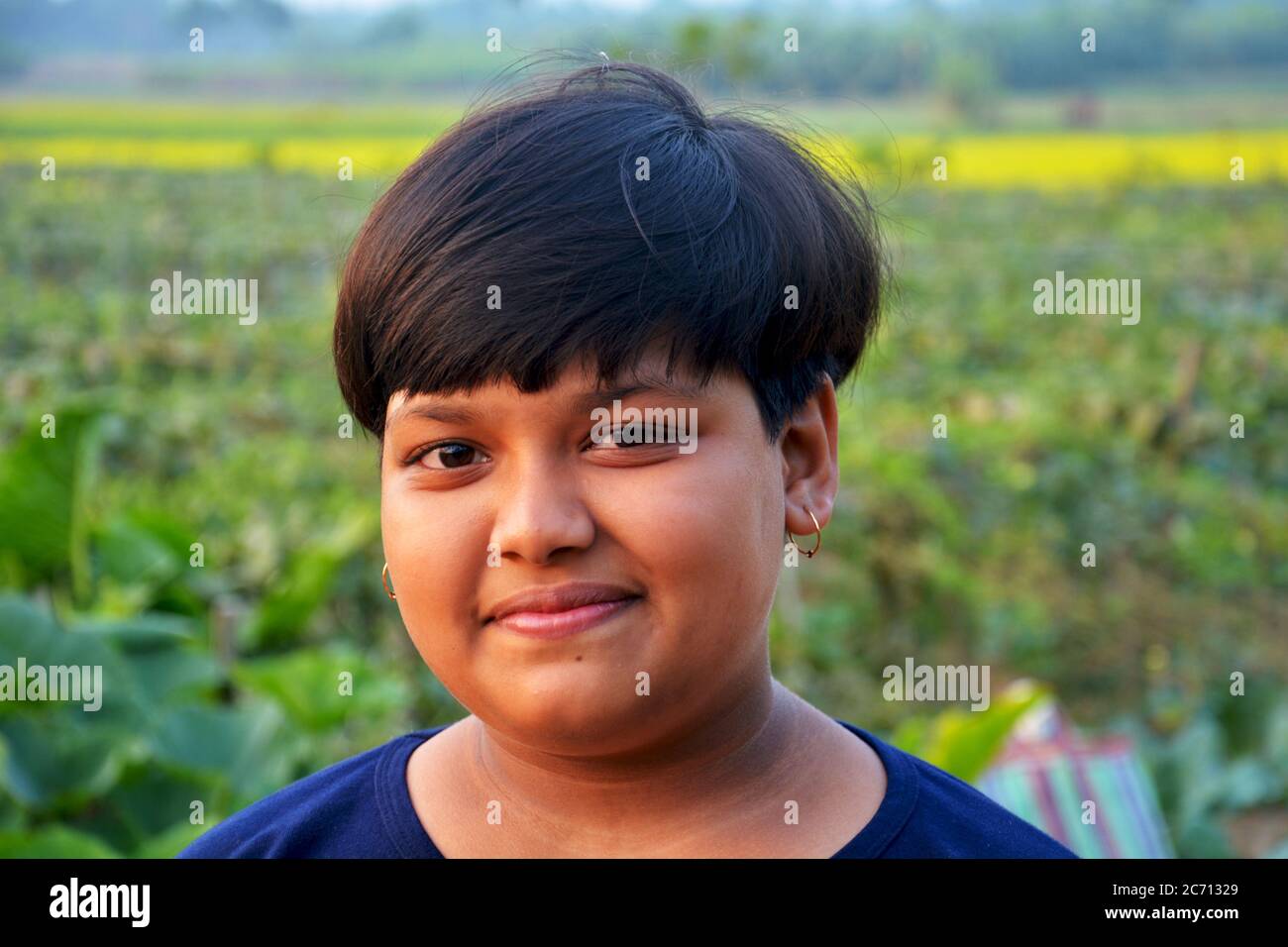 Une adolescente indienne souriant dans un village rural, en se concentrant de manière sélective Banque D'Images