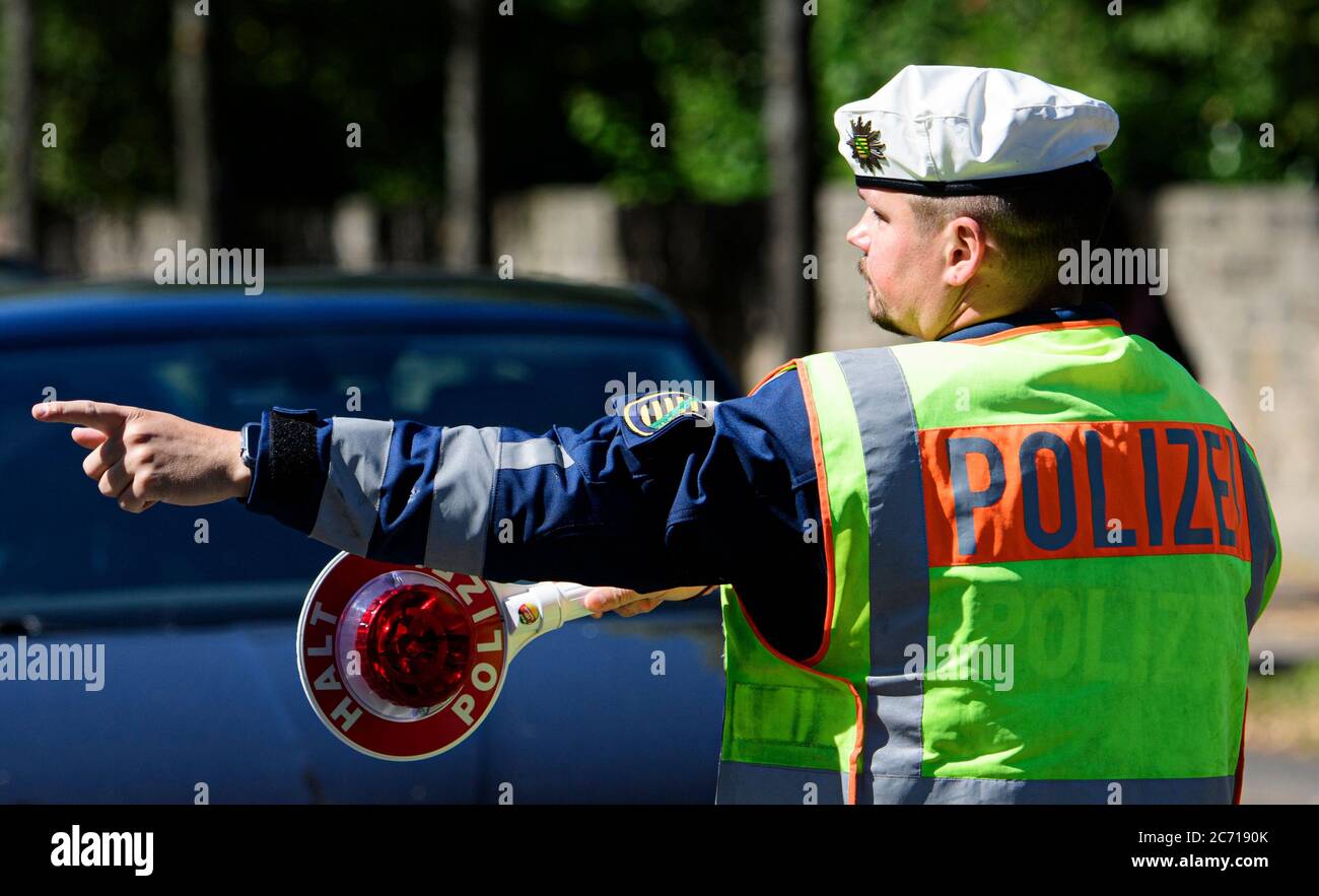 Dresde, Allemagne. 13 juillet 2020. Un policier de moto fait passer une truelle de police sur le côté d'un automobiliste pendant un contrôle de police, qui vérifie que la distance minimale de 1.5 mètres est observée lors du dépassement des cyclistes. Avec ce projet de sécurité, le quartier général de la police de Dresde et l'ADFC Saxe souhaitent attirer l'attention sur la modification du Règlement sur la circulation routière, dans lequel des règlements spécifiques sur la distance ont été introduits pour le dépassement, et pour sensibiliser les usagers de la route en conséquence. Crédit : Robert Michael/dpa-Zentralbild/dpa/Alay Live News Banque D'Images