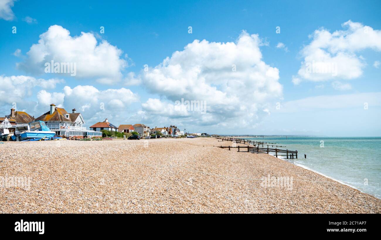 Pevensey Bay, East Sussex, Angleterre. Des maisons de plage traditionnelles le long de la côte sud de l'Angleterre lors d'une journée d'été lumineuse. Banque D'Images