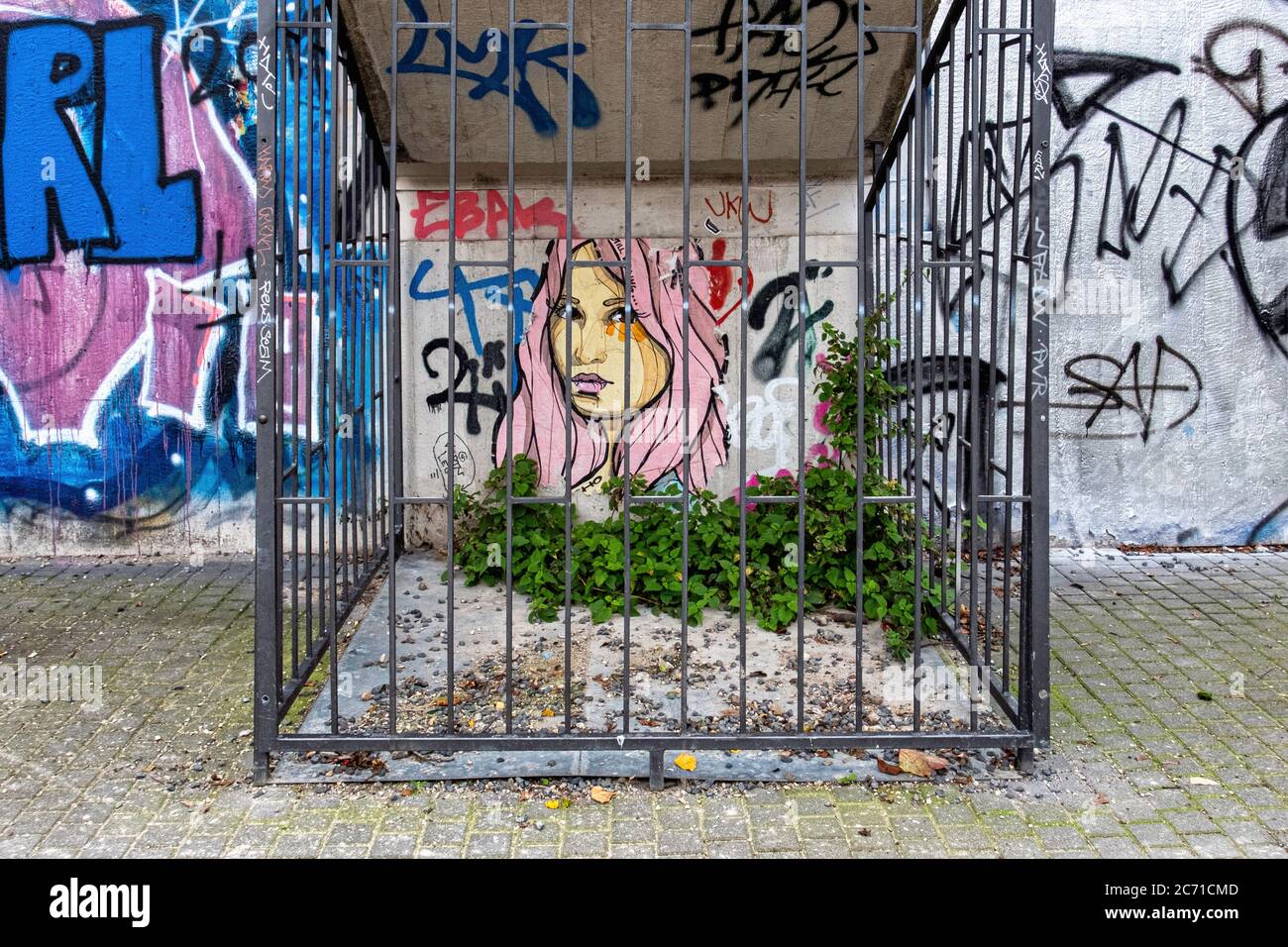 Pâte Street Art. 'Still Falling' femme et nettles derrière les bars par El Bocho à Mitte, Berlin, Allemagne Banque D'Images
