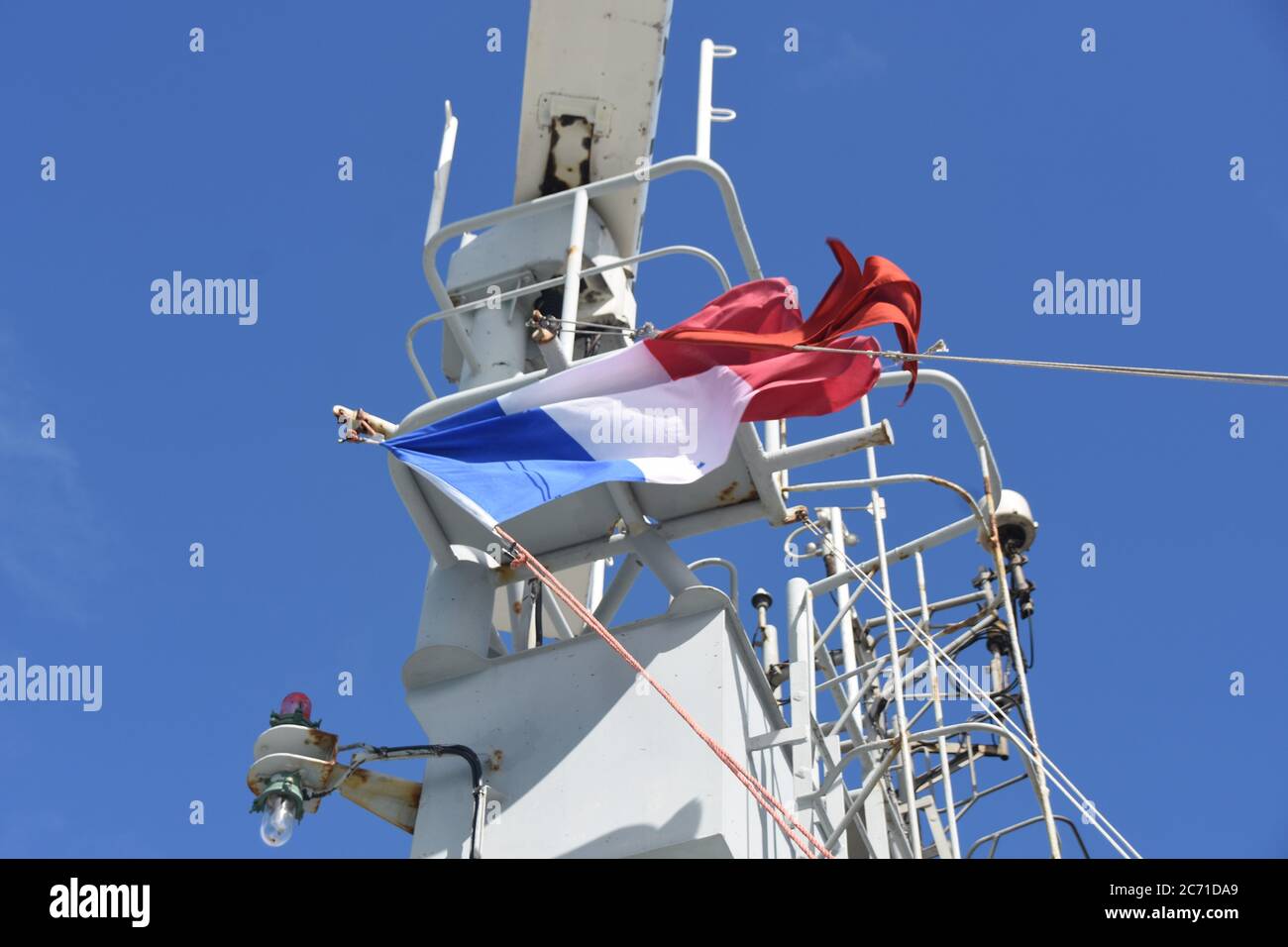 Français et rouge UN drapeau représente les marchandises dangereuses transportées sur le navire battant sur le mât du navire de soute marchand. Banque D'Images