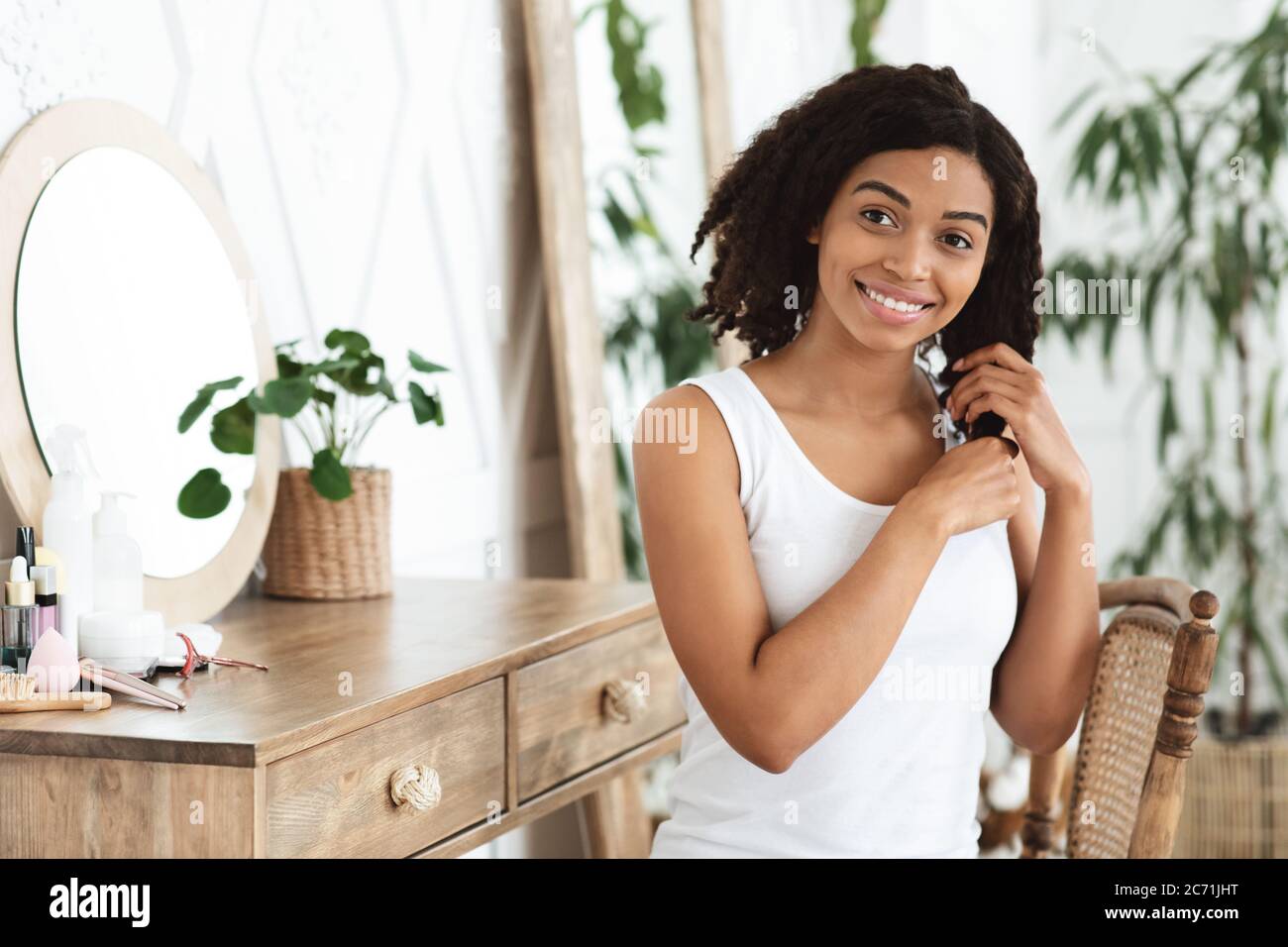 Concept d'auto-soins et de bien-être. Bonne femme noire appréciant toucher  ses beaux cheveux Photo Stock - Alamy