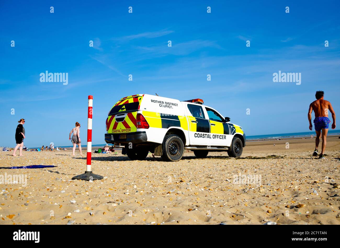 Voiture de pick-up 4x4 d'officier côtier au bord de la mer avec des gens en arrière-plan, district de Rother, Camber Beach Sands en Angleterre. Banque D'Images