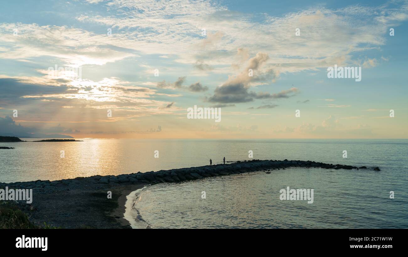 Silhouette de pêcheur décontractée sur la jetée à l'heure bleue Banque D'Images