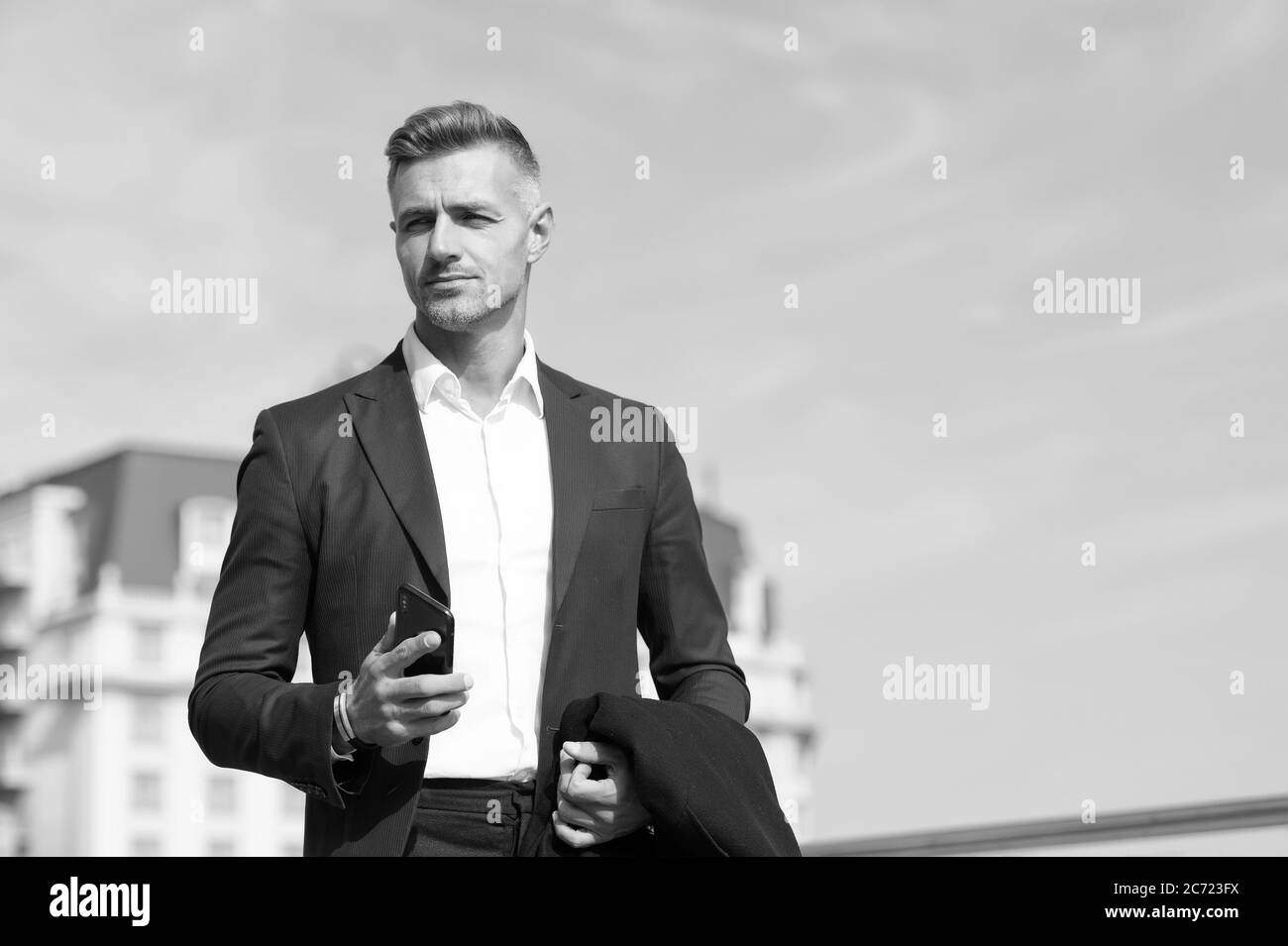 Prenez des décisions en déplacement. Communication mobile. Homme d'affaires réussi et motivé. Homme d'affaires bien entretenu coiffure. Concept d'entreprise. Vie d'affaires. Fond bleu ciel de style classique homme. Banque D'Images