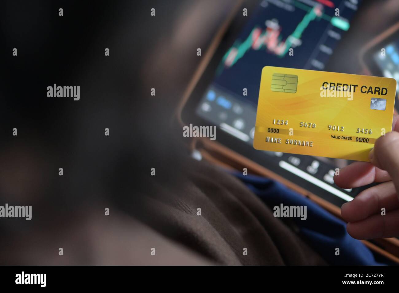 Homme d'affaires tient des cartes de crédit pour Forex ou bourse dans le smartphone de tablette Banque D'Images