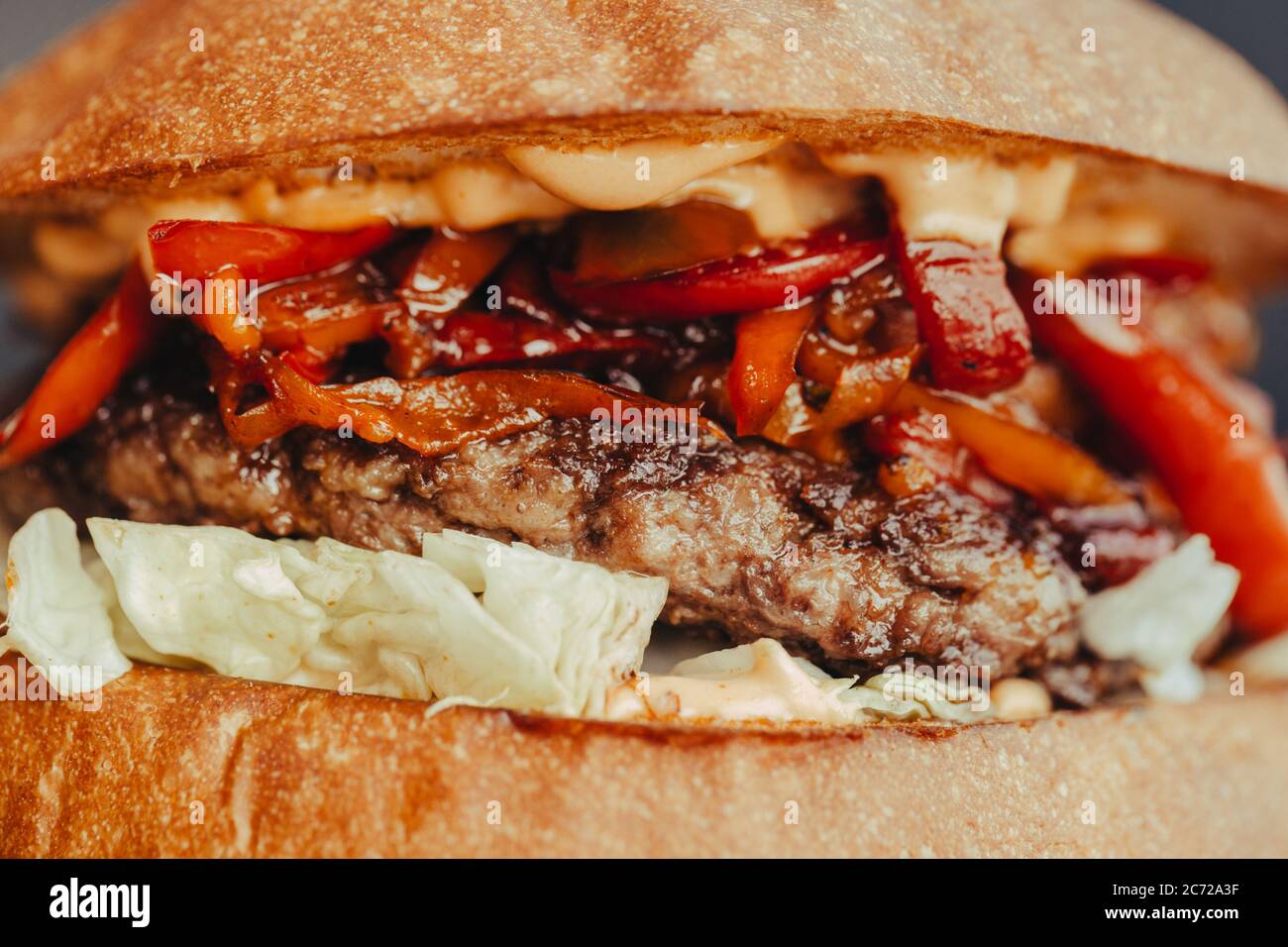 Circulaire Burger. Hamburger au fromage avec viande grillée, fromage, salade et rondelles d'oignon. Gros plan de délicieux hamburgers maison frais sur fond bleu écorce Banque D'Images