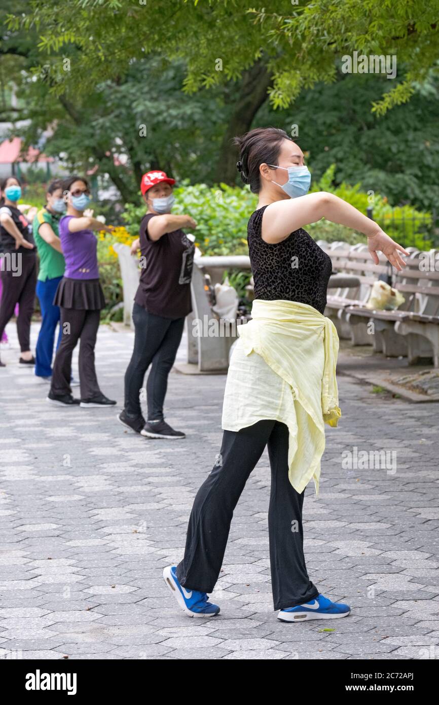 Avec une distance sociale appropriée et des masques de port, un groupe de femmes asiatiques américaines pratiquent la danse chinoise moderne. À Kissena Park, Flushing, New York. Banque D'Images