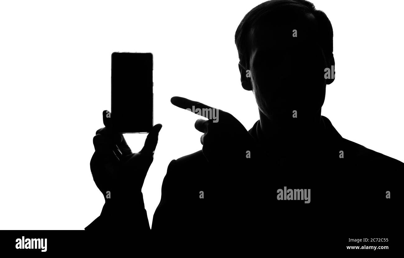 Portrait d'un jeune homme en costume sur un smartphone, tablette en main - silhouette Banque D'Images