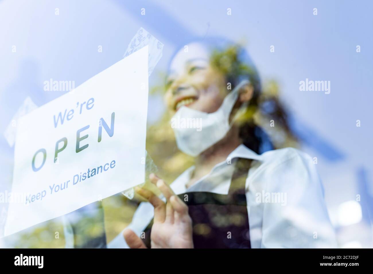 Concentrez-vous sur la signalisation du restaurant. Serveuse asiatique mettant sur une signalisation ouverte avec distance sociale pour un nouveau restaurant normal. Nouveau restaurant normal Banque D'Images