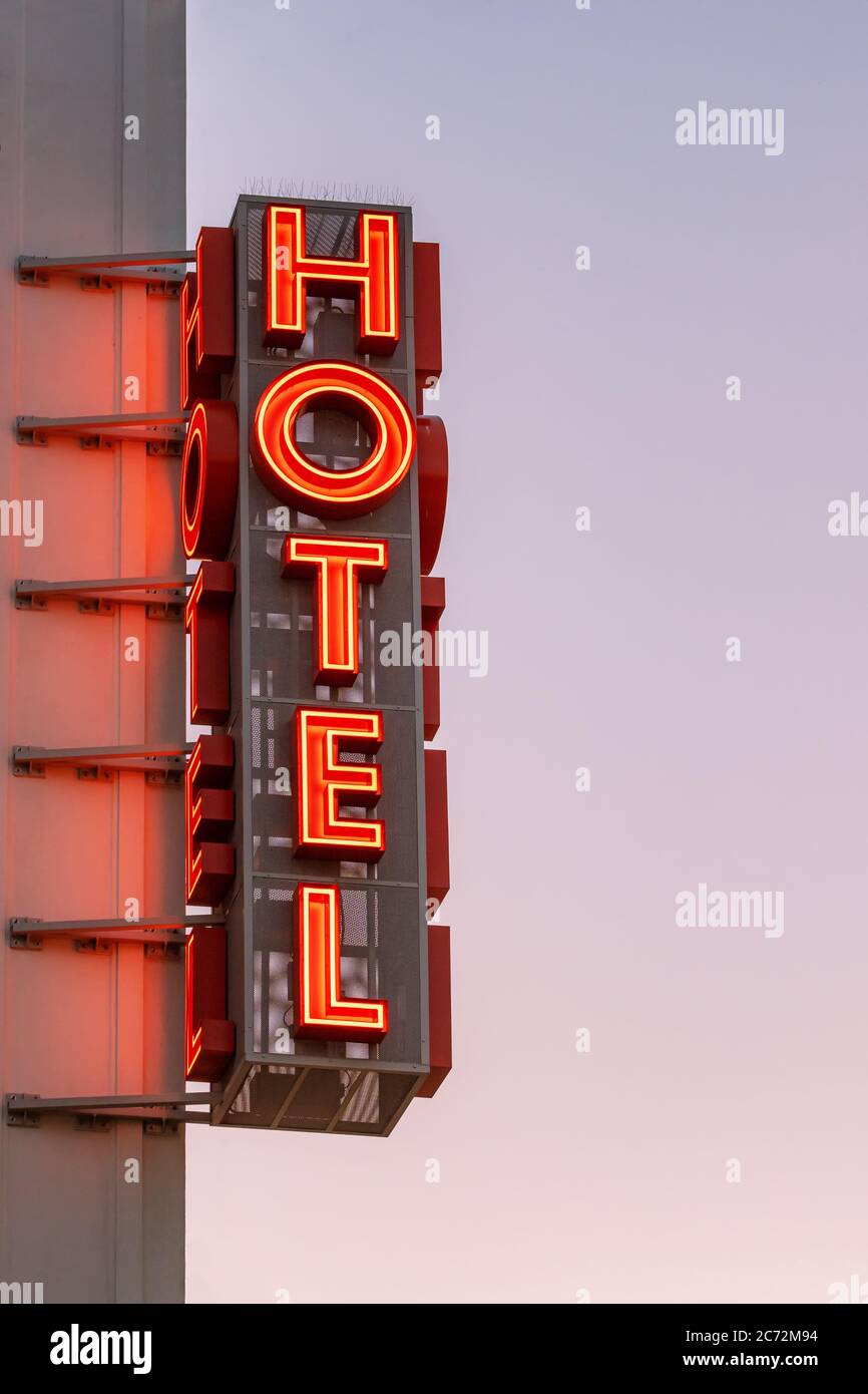 Le panneau de l'hôtel au néon est situé à l'angle du bâtiment, contre le ciel du coucher du soleil Banque D'Images