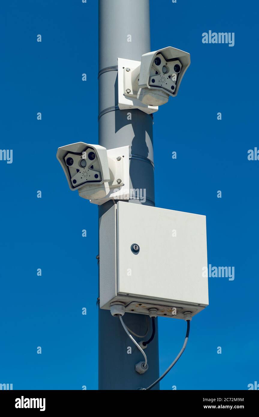 Caméras de surveillance sur un poteau contre un ciel bleu. Banque D'Images