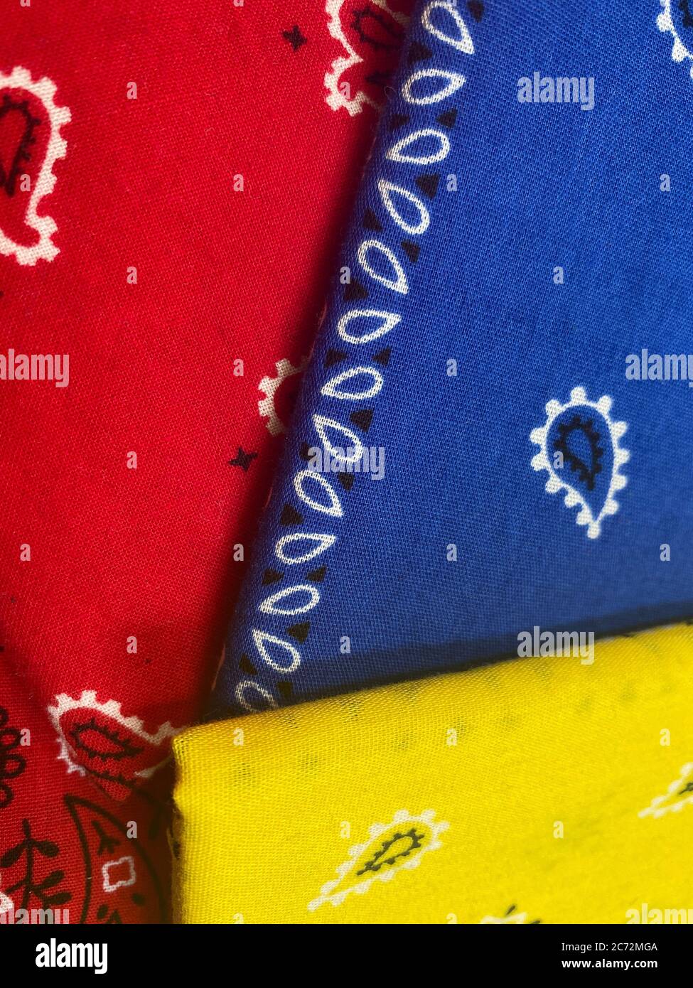 Trois bandanas en coton de couleur vive à utiliser comme revêtements faciaux pendant la pandémie du coronavirus Banque D'Images